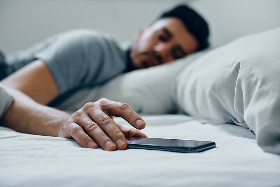 ベッド_男_スマホ_時間を気にする男
