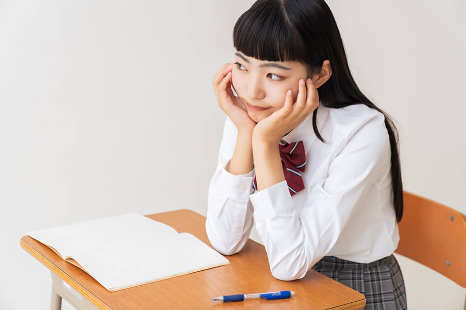 学生_机_あごを手にのせる