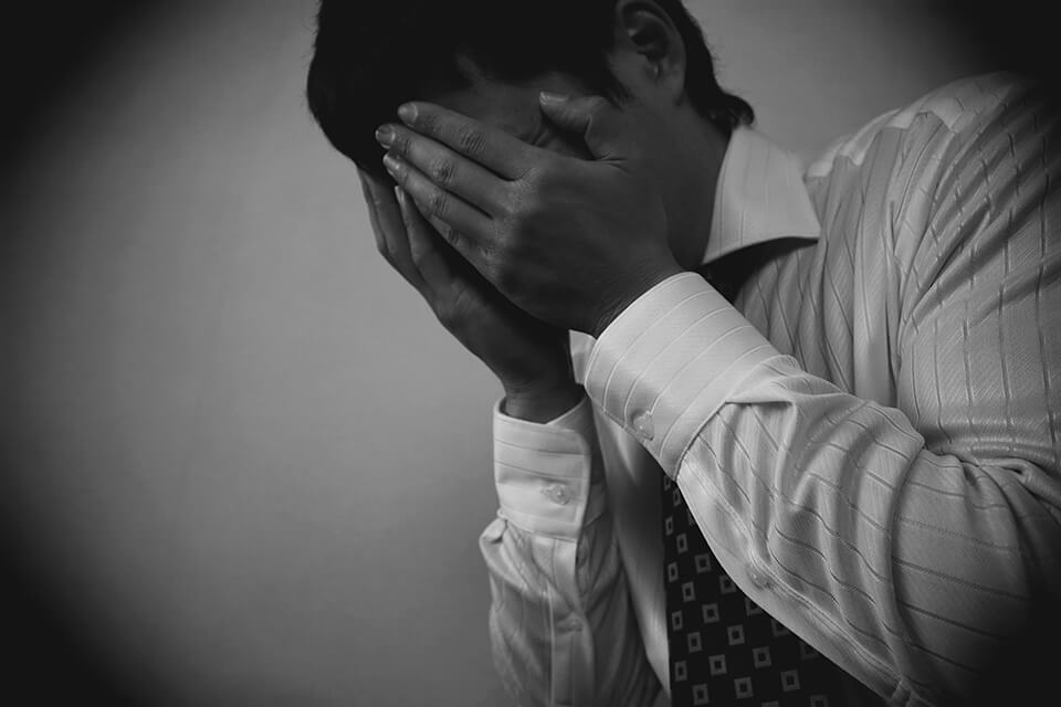 顔を抑える男