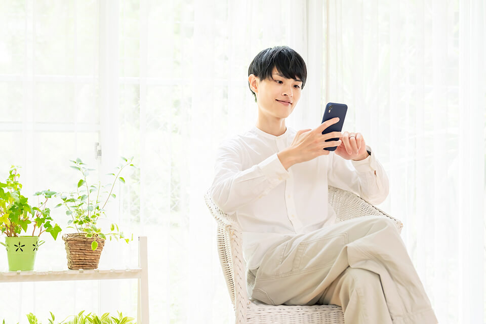 若い男_スマホ_白い部屋