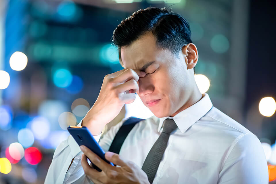 スマホを見る_こめかみを抑える_スーツ_男