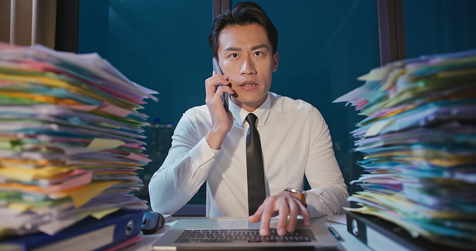 男_書類山積み_電話