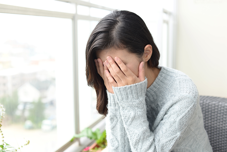 顔を抑える女