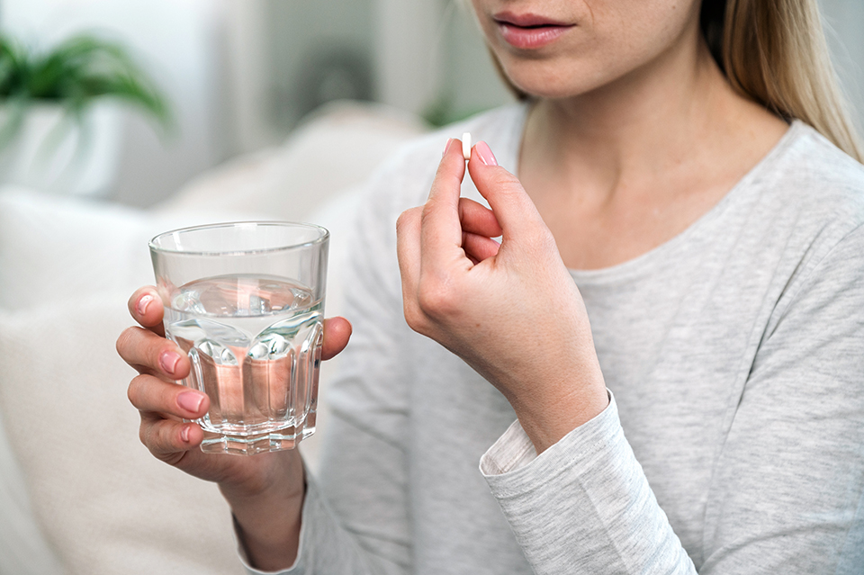 薬を飲む女_コップに水