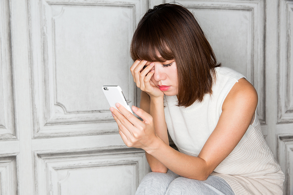 スマホ_女_頭を抱える